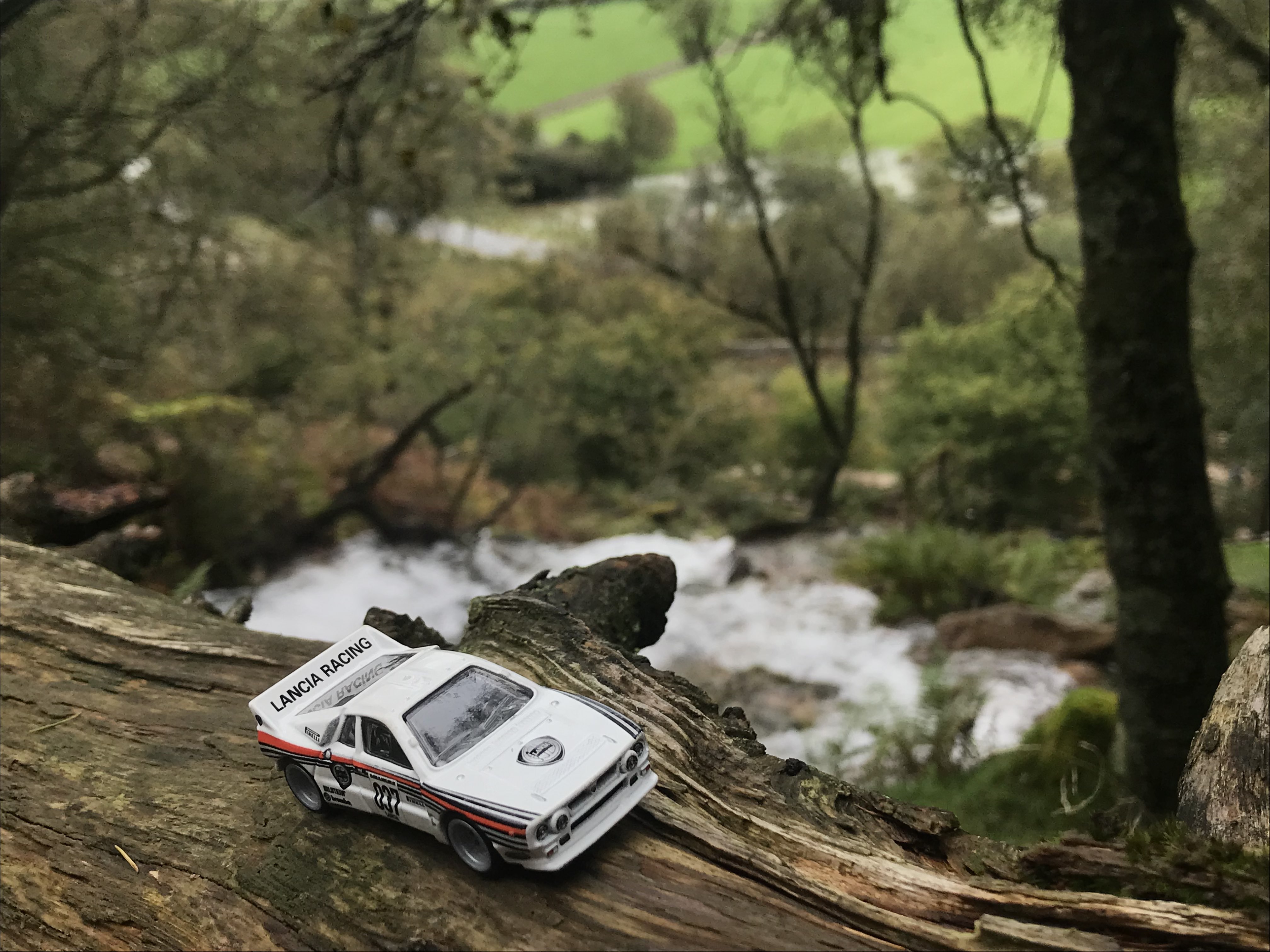 Hotwheels GrpB  Rally Lancia 037 driving along some wood, with waterfall in the background [GTA 3 Theme]