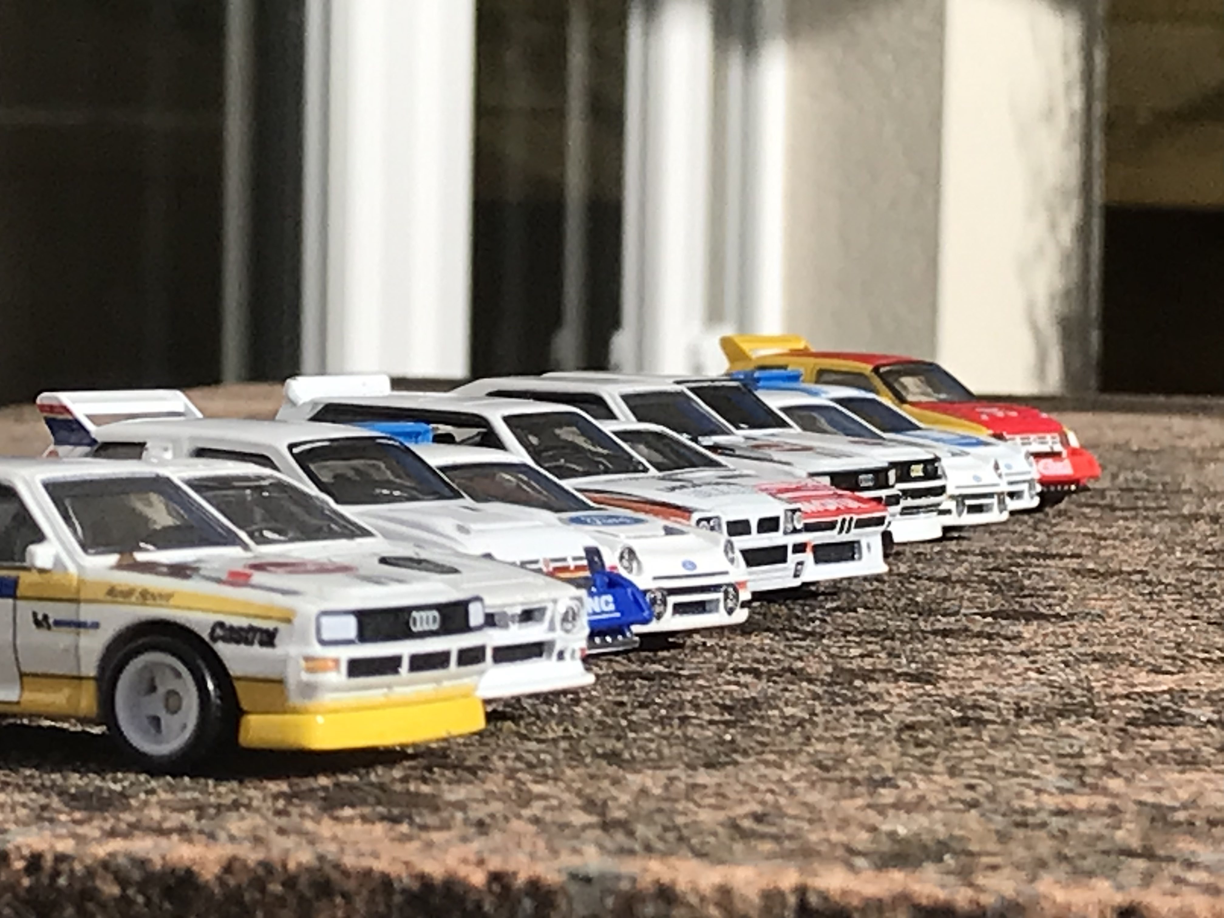 Various Hotwheel Group B Rally cars of various makes and models, lined up diagonally away from the camera. [Boards of Canada - Dayvan Cowboy]