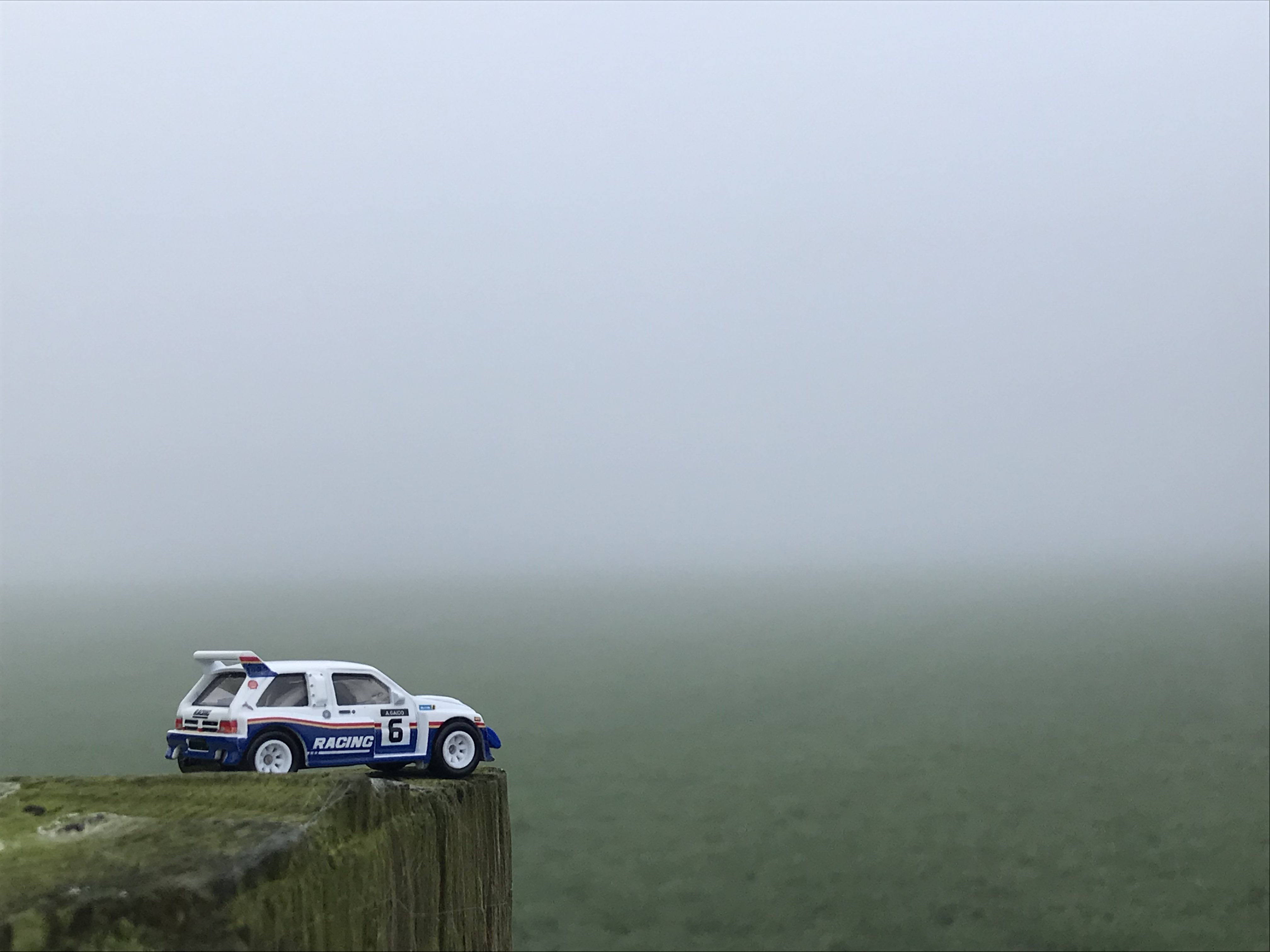 Hotwheels Grp B Rally MG Metro 6R4, parked on the edge of some wood. The background is a very foggy grass field [Silent Hill 2 OST - The Day Of Night]